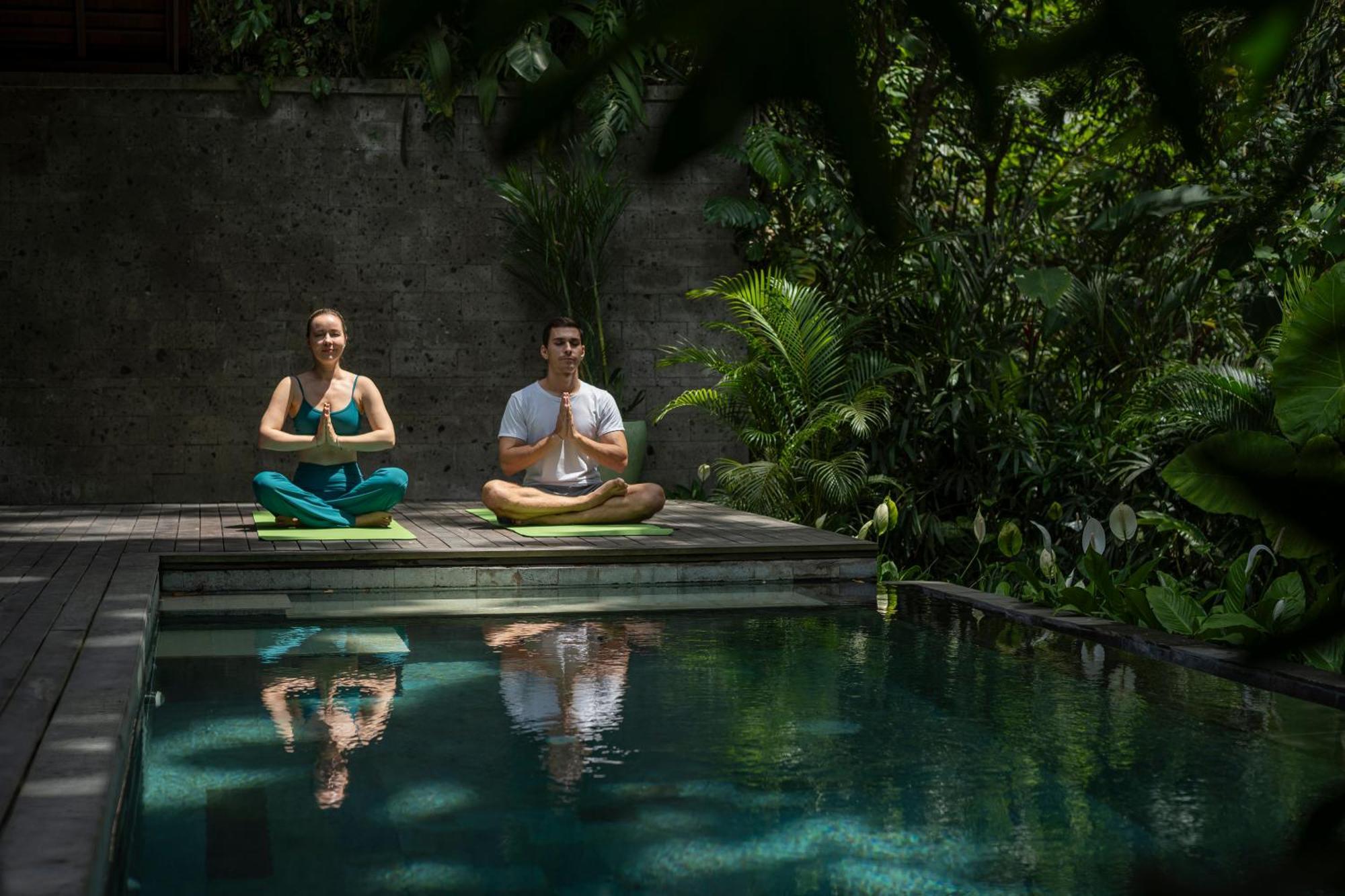 ホテル アディワナ スウェタ【Chse認定】 ウブド エクステリア 写真 A couple practicing yoga at the Bvlgari Spa